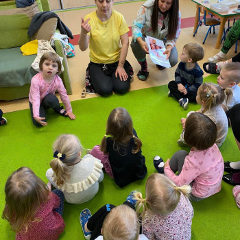 Grupa dzieci siedzących na dywanie