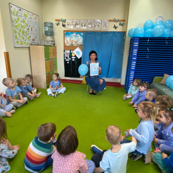 Dzieci siedzące w kole słuchające opowiadania