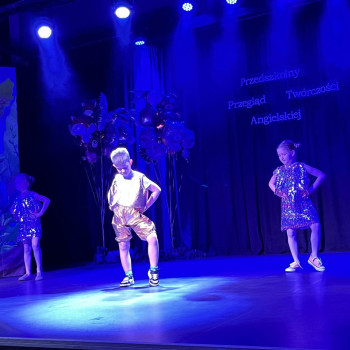 Grupa taneczna podczas występu, scena oświetlona na niebiesko